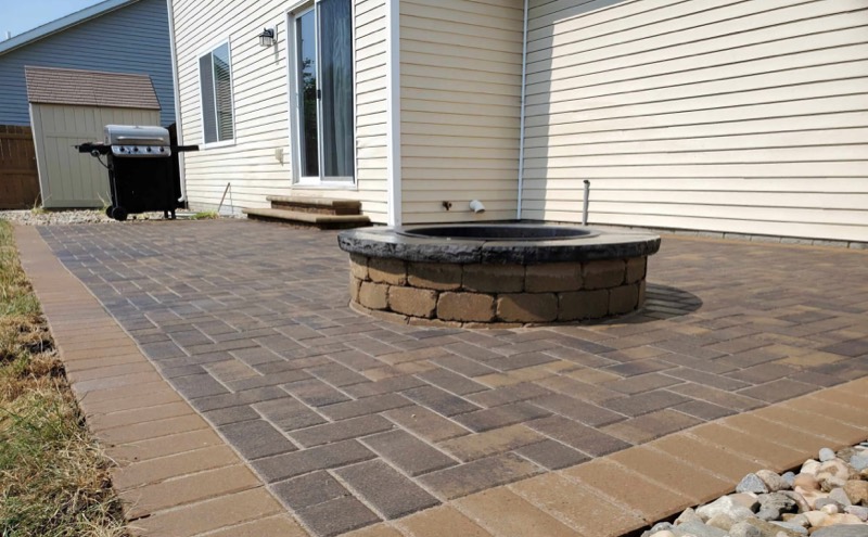 Herringbone paver patio with a built-in block fireplace