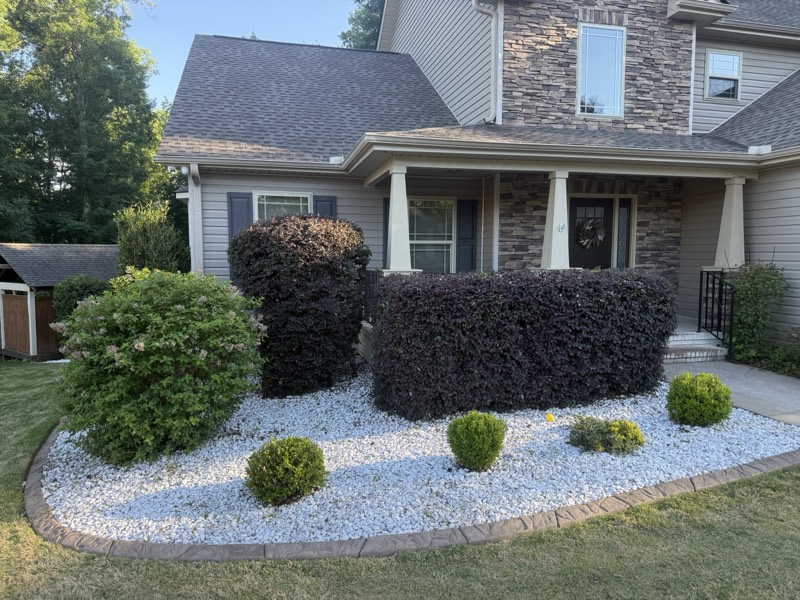 Front foundation beds with shrubs, river stone and a brick border