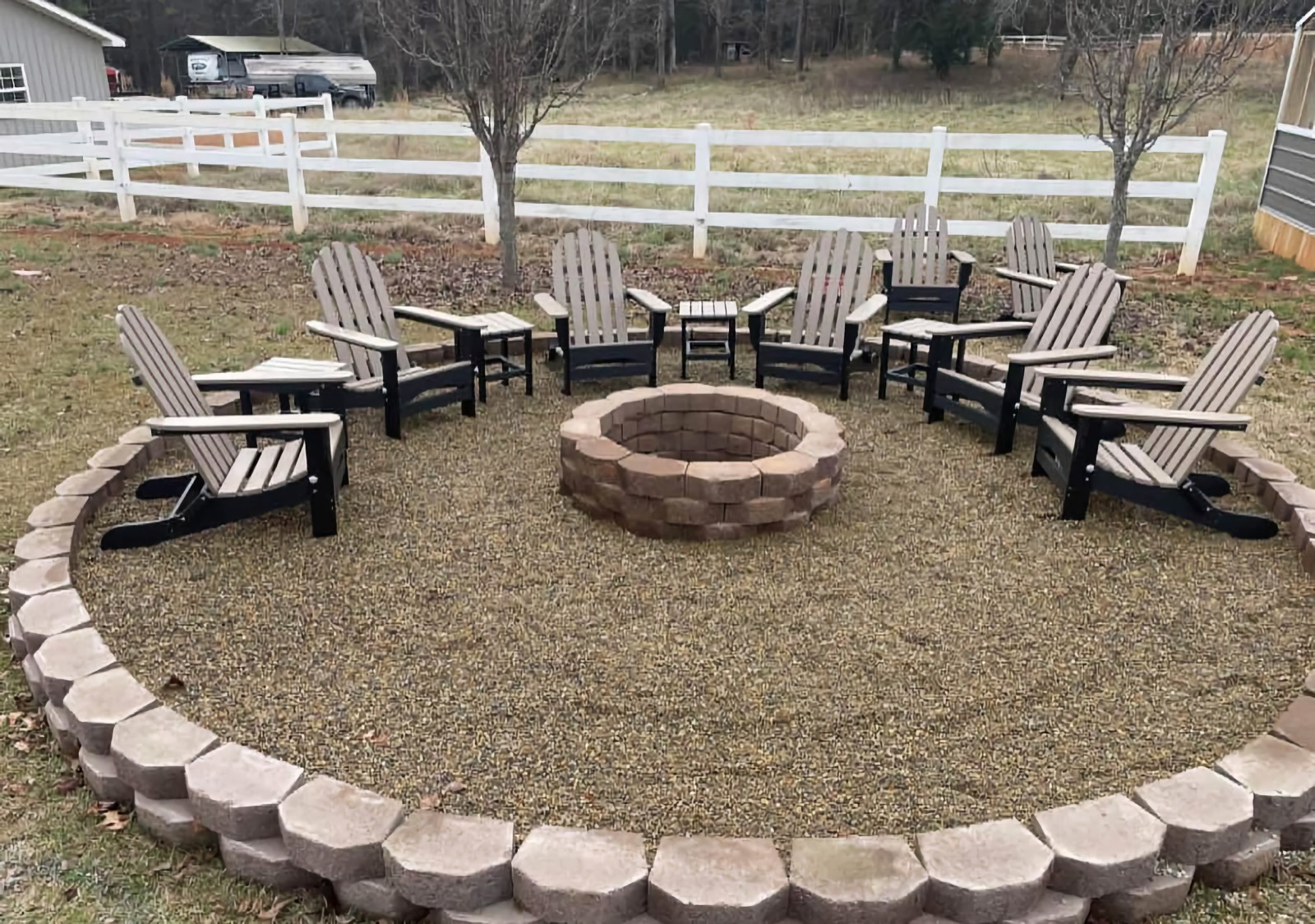 Circular fire pit with pea-gravel seating and Adirondack chairs