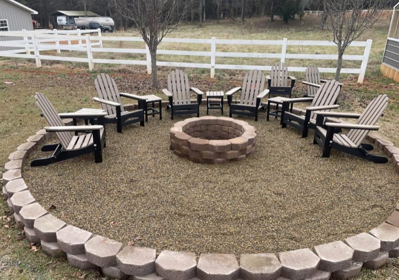 Circular fire pit with pea-gravel seating and Adirondack chairs