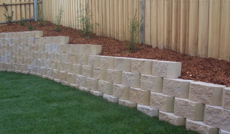 Segmental block retaining wall with mulched terrace and young trees